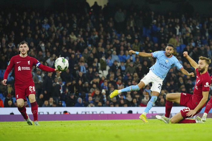 Manchester Citys Riyad Mahrez, centre, scores his sides second goal during the English League Cup soccer match between Manchester City and Liverpool at Etihad stadium in Manchester, England, Thursday, Dec. 22, 2022. (AP Photo/Jon Super)