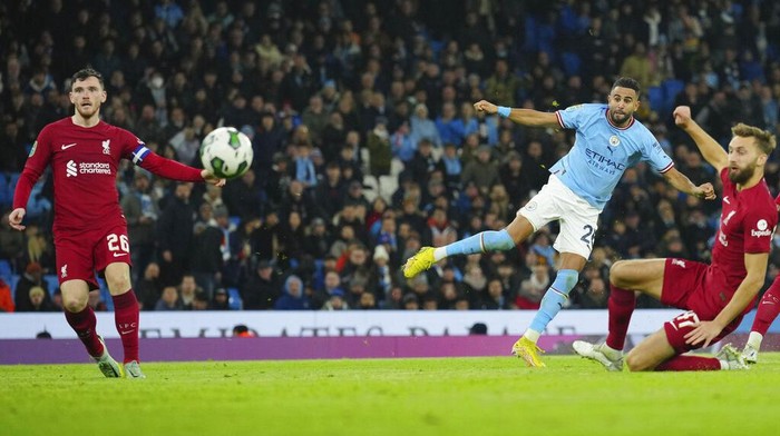Manchester City's Riyad Mahrez, centre, scores his sides second goal during the English League Cup soccer match between Manchester City and Liverpool at Etihad stadium in Manchester, England, Thursday, Dec. 22, 2022. (AP Photo/Jon Super)