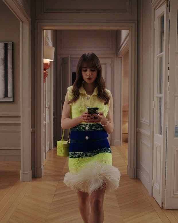 Emily dengan Outfit Berbahan Rajut dan Berbulu. Foto: Netflix Emily in Paris Emily dengan Outfit Berbahan Rajut dan Berbulu. Foto: Netflix Emily in Paris