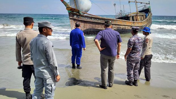 Stasiun Bakamla Banda Ace membantu evakuasi imigran ilegal Suku Rohingya asal Myanmar. Kapal kayu yang membawa imigran itu  karam di Pantai Desa Ladong, Aceh Besar, Minggu (25/12/2022). (Dok. humas Bakamla)