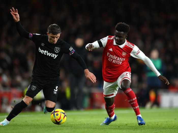 LONDON, ENGLAND - DECEMBER 26: Aaron Cresswell of West Ham United is challenged by Bukayo Saka of Arsenal during the Premier League match between Arsenal FC and West Ham United at Emirates Stadium on December 26, 2022 in London, England. (Photo by Justin Setterfield/Getty Images)