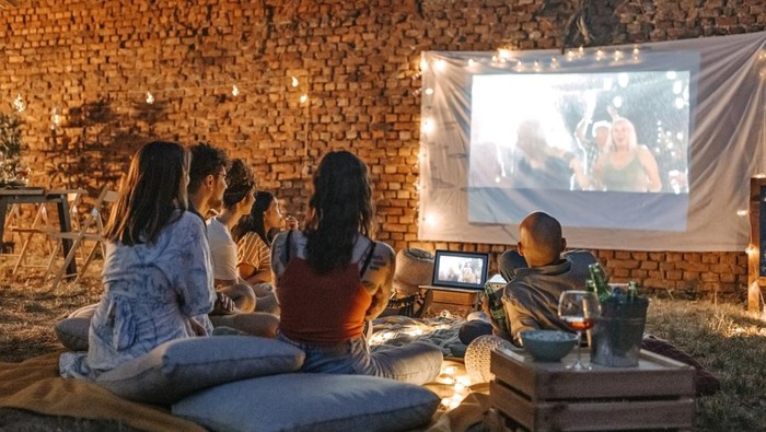 Ilustrasi Kegiatan Malam Tahun Baru Seru Photo of friends at backyard movie night.