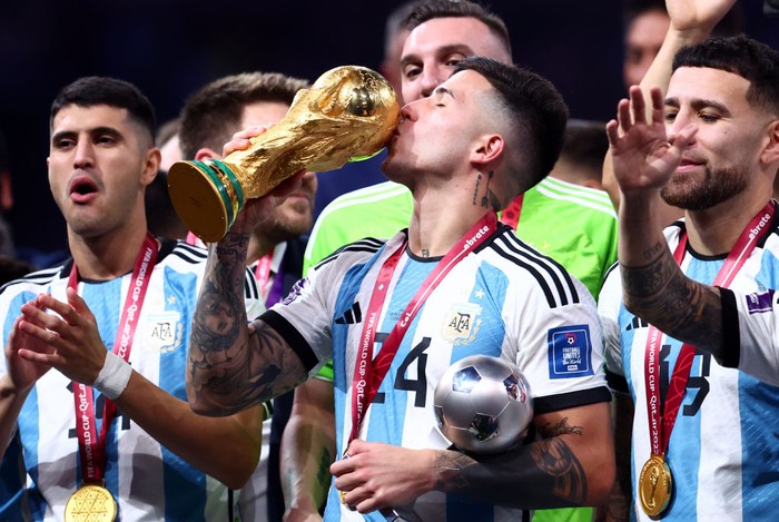LUSAIL CITY, QATAR - DECEMBER 18:   Enzo Fernandez of Argentina kisses the World Cup trophy at the end of the FIFA World Cup Qatar 2022 Final match between Argentina and France at Lusail Stadium on December 18, 2022 in Lusail City, Qatar. (Photo by Chris Brunskill/Fantasista/Getty Images)