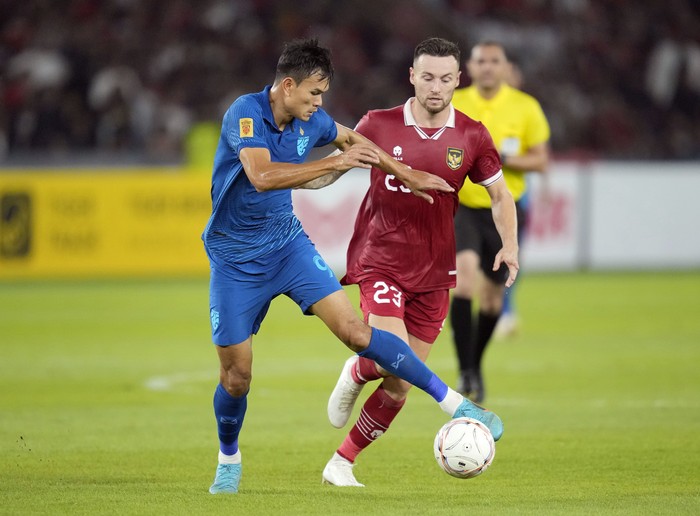 Indonesias Marc Anthony Klok, right, fights for the ball with Thailands Adisak Kraisorn, left, during the ASEAN Football Federation (AFF) Mitsubishi Electric Cup 2022 Group A soccer match at Gelora Bung Karno Main Stadium in Jakarta, Indonesia, Thursday, Dec. 29, 2022. (AP Photo/Achmad Ibrahim)