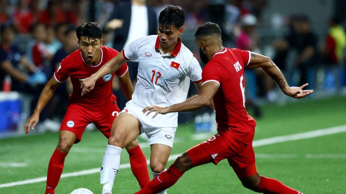 KALLANG, SINGAPORE - DECEMBER 30: Vu Van Thanh #17 of Vietnam competes for the ball against Song Ui-Young #7 (L) and Anumanthan Kumar #6 of Singapore in the second half during the AFF Mitsubishi Electric Cup Group B match at Jalan Besar Stadium on December 30, 2022 in Kallang, Singapore. (Photo by Yong Teck Lim/Getty Images)