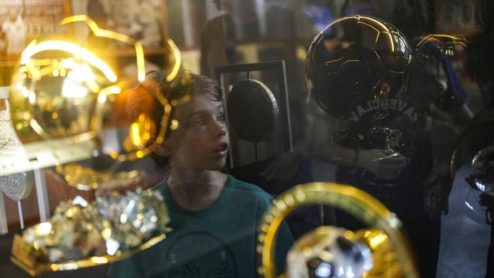 Mengenang Pele Lewat Museum Sang Legenda di Brasil A boy is reflected on a glass case as he tours the Pele Museum in Santos, Brazil, Monday, Dec. 26, 2022. (AP Photo/Matias Delacroix)