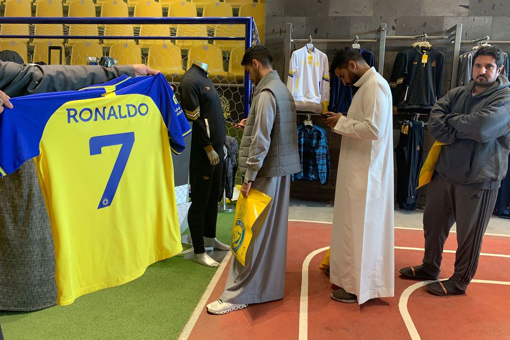 A fan holds t-shirt bearing the name Ronaldo and number 7, at the Saudi Al Nassr FC shop in the Saudi capital Riyadh, on December 31, 2022. - Cristiano Ronaldo on December 30 signed for Al Nassr of Saudi Arabia, the club announced, in a deal believed to be worth more than 200 million euros. The 37-year-old penned a contract which will take him to June 2025. (Photo by Fayez Nureldine / AFP) (Photo by FAYEZ NURELDINE/AFP via Getty Images)