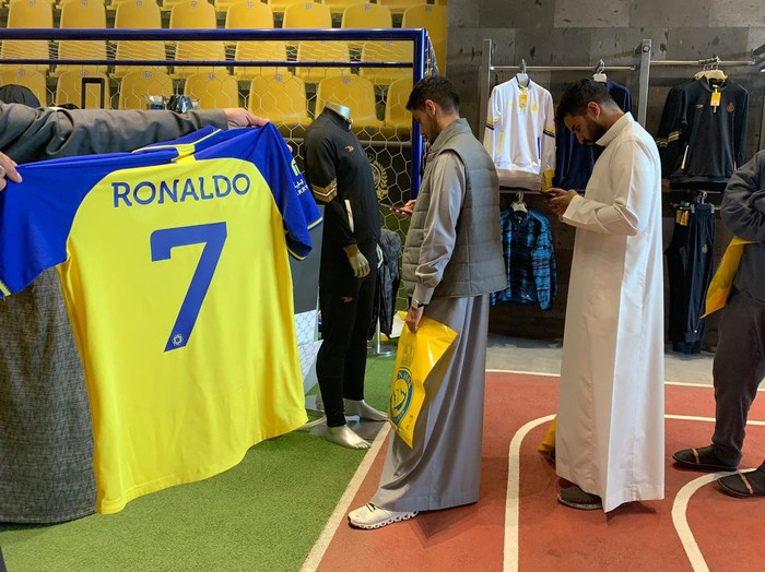 A fan holds t-shirt bearing the name Ronaldo and number 7, at the Saudi Al Nassr FC shop in the Saudi capital Riyadh, on December 31, 2022. - Cristiano Ronaldo on December 30 signed for Al Nassr of Saudi Arabia, the club announced, in a deal believed to be worth more than 200 million euros. The 37-year-old penned a contract which will take him to June 2025. (Photo by Fayez Nureldine / AFP) (Photo by FAYEZ NURELDINE/AFP via Getty Images)