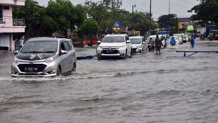 Sejumlah kendaraan menerobos jalan nan tergenang banjir di jalan Jalur Pantura Desa Jati Wetan, Kudus, Jawa Tengah, Minggu (1/1/2023). Banjir akibat curah hujan tinggi itu menyebabkan kemacetan dari arah Kudus menuju Semarang dan sebaliknya. ANTARA FOTO/Yusuf Nugroho/rwa.