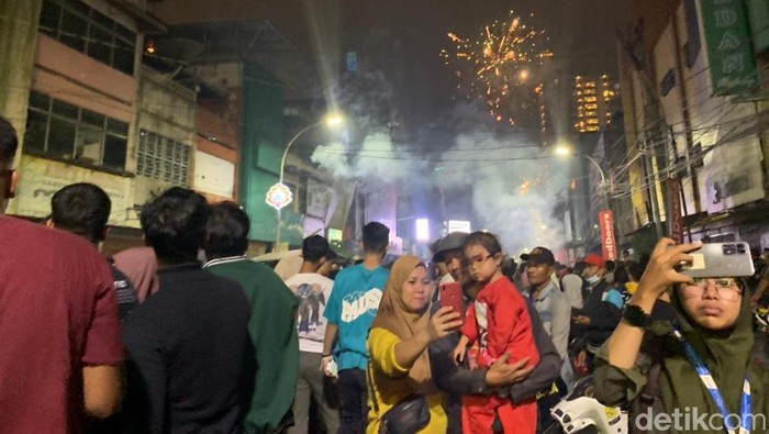 Warga bersemangat menyaksikan pesta kembang api di Jalan Zainul Arifin Medan (Kartika Sari/detikSumut)