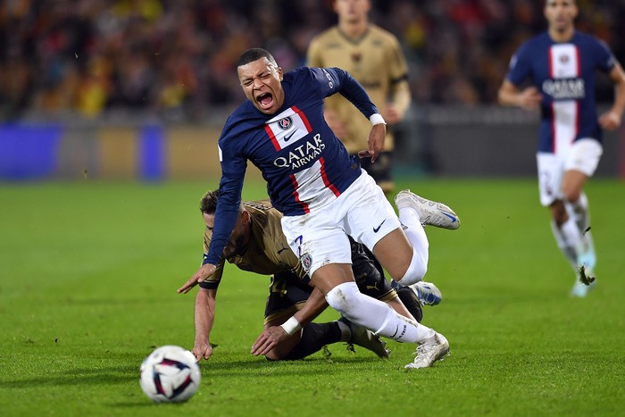 LENS, FRANCE - JANUARY 01: Kylian Mbappe of Paris Saint-Germain is tackled during the Ligue 1 match between RC Lens and Paris Saint-Germain at Stade Bollaert-Delelis on January 01, 2023 in Lens, France. (Photo by Aurelien Meunier/Getty Images)