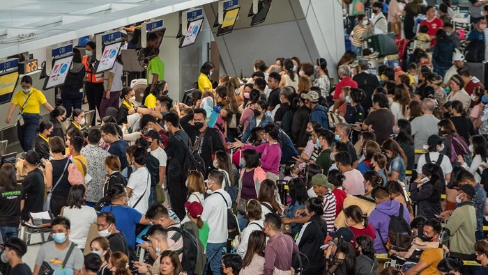 Passengers wait for information about their flights at terminal 3 of Ninoy Aquino International Airport in Pasay, Metro Manila on January 1, 2023. - Thousands of travellers were stranded at Philippine airports on January 1 after a 