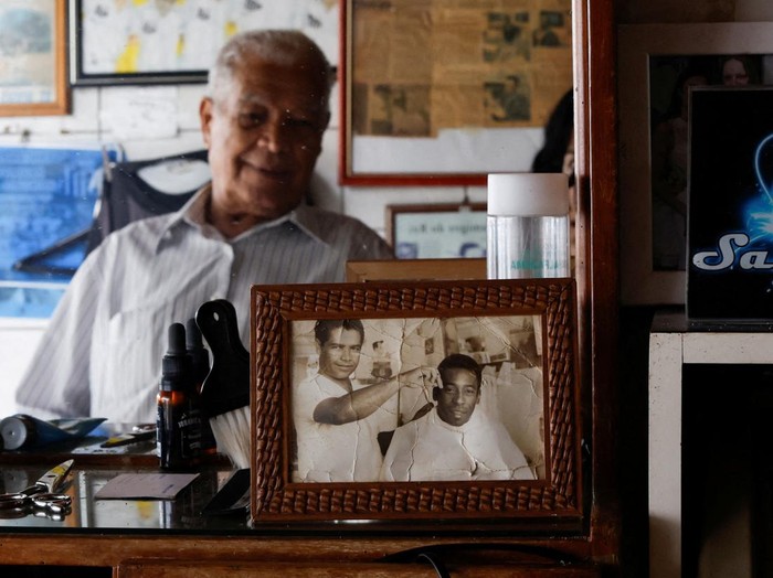 Joao Araujo, know as Didi, 84, who was hairdresser to Brazilian soccer legend Pele, holds a picture of himself with Pele, as he mourns his death, in Santos, Brazil, December 30, 2022. REUTERS/Amanda Perobelli