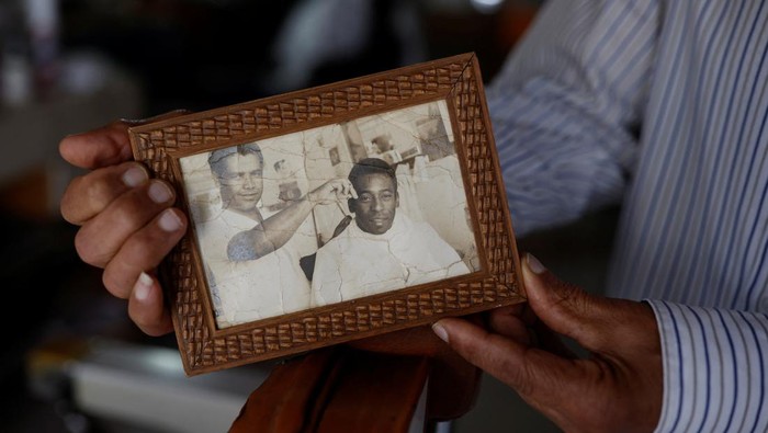 Sosok Didi Si Tukang Cukur Rambut Pele Joao Araujo, know as Didi, 84, who was hairdresser to Brazilian soccer legend Pele, holds a picture of himself with Pele, as he mourns his death, in Santos, Brazil, December 30, 2022. REUTERS/Amanda Perobelli