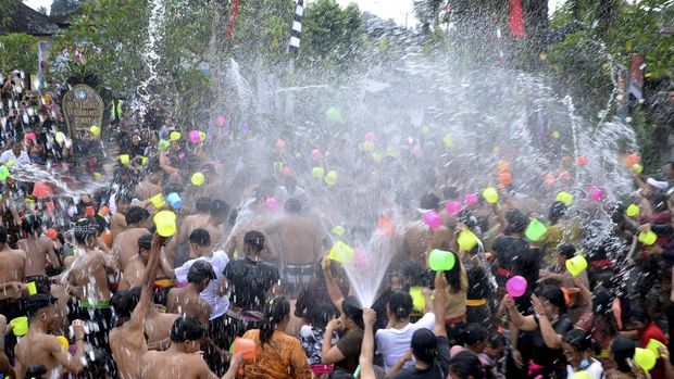 Sejumlah warga saling menyiramkan air saat mengikuti tradisi perang air yang merupakan rangkaian Festival Air Suwat di Desa Suwat, Gianyar, Bali, Minggu (1/1/2023). Tradisi perang air tersebut dilakukan warga setahun sekali untuk membersihkan diri secara lahir dan batin, memperkuat rasa persaudaraan warga serta untuk mengenalkan potensi seni, budaya dan pariwisata setempat kepada wisatawan. ANTARA FOTO/Fikri Yusuf/rwa.