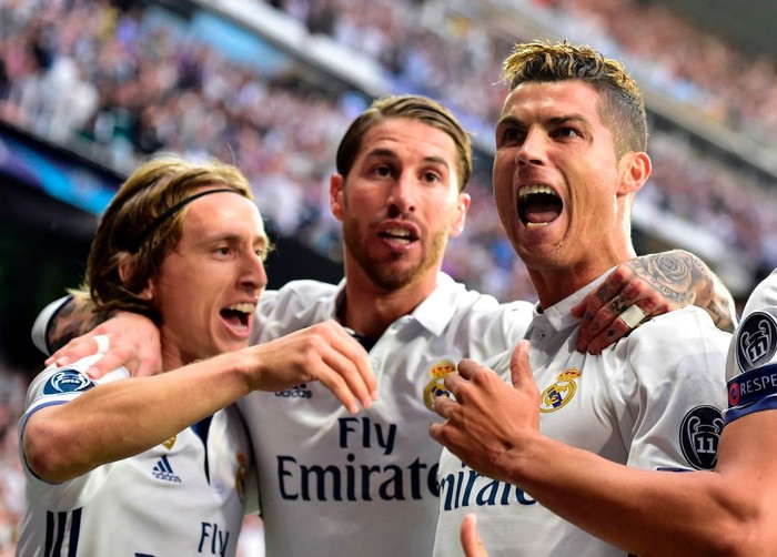 TOPSHOT - Real Madrids Portuguese forward Cristiano Ronaldo (R) celebrates with Real Madrids Croatian midfielder Luka Modric (L) and Real Madrids defender Sergio Ramos after scoring during the UEFA Champions League semifinal first leg football match Real Madrid CF vs Club Atletico de Madrid at the Santiago Bernabeu stadium in Madrid, on May 2, 2017. / AFP PHOTO / GERARD JULIEN        (Photo credit should read GERARD JULIEN/AFP via Getty Images)