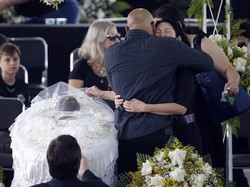 Marcia Cibele Aoki menangis sambil memeluk Edinho. Edinho merupakan putra Pele dari istri pertama. Reuters/Diego Vara.