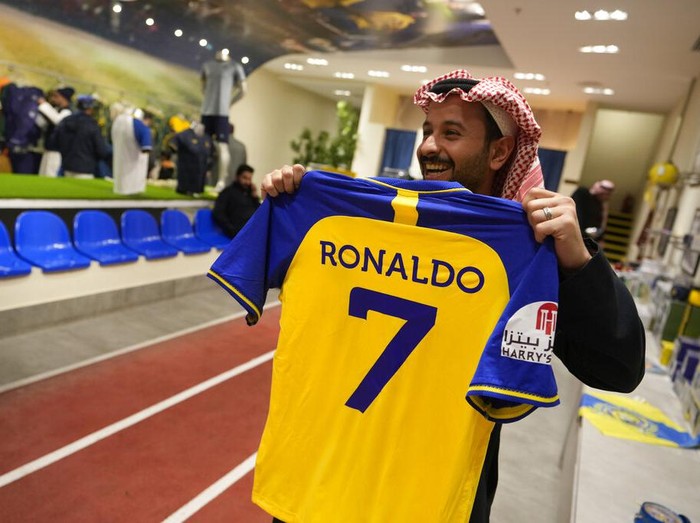 An employee prints out Cristiano Ronaldo jerseys at Al Nassr soccer club store in Riyadh, Saudi Arabia, Monday, Jan 2, 2023. Ronaldo completed a lucrative move to Saudi Arabian club Al Nassr on Friday in a deal that is a landmark moment for Middle Eastern soccer but will see one of Europe's biggest stars disappear from the sport's elite stage. (AP Photo/Amr Nabil)