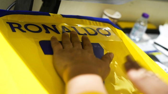 An employee prints out Cristiano Ronaldo jerseys at Al Nassr soccer club store in Riyadh, Saudi Arabia, Monday, Jan 2, 2023. Ronaldo completed a lucrative move to Saudi Arabian club Al Nassr on Friday in a deal that is a landmark moment for Middle Eastern soccer but will see one of Europe's biggest stars disappear from the sport's elite stage. (AP Photo/Amr Nabil)