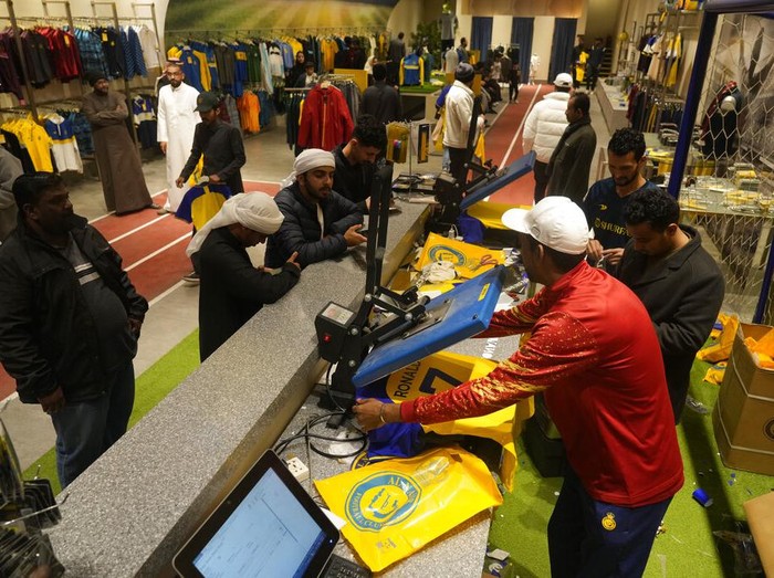 An employee prints out Cristiano Ronaldo jerseys at Al Nassr soccer club store in Riyadh, Saudi Arabia, Monday, Jan 2, 2023. Ronaldo completed a lucrative move to Saudi Arabian club Al Nassr on Friday in a deal that is a landmark moment for Middle Eastern soccer but will see one of Europe's biggest stars disappear from the sport's elite stage. (AP Photo/Amr Nabil)