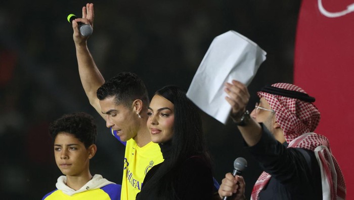 Al-Nassrs new Portuguese forward Cristiano Ronaldo (C-L), his partner Georgina Rodriguez (C-R) and his son Cristiano Ronaldo Jr (L) take the stage during the unveiling ceremony at the Mrsool Park Stadium in the Saudi capital Riyadh on January 3, 2023. (Photo by Fayez Nureldine / AFP) (Photo by FAYEZ NURELDINE/AFP via Getty Images)