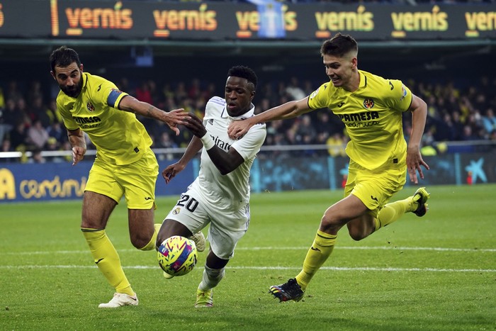Villarreals Raul Albiol, left, and Juan Foyth try to stop Real Madrids Vinicius Junior during the Spanish La Liga soccer match between Villareal and Real Madrid at Estadio De La Ceramica in Villareal, eastern Spain, Saturday, Jan. 7, 2023. (AP Photo/Alberto Saiz)