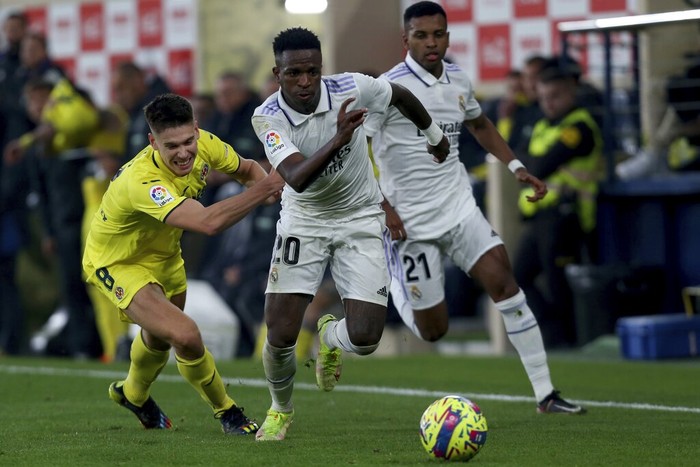 Villarreals Juan Foyth, left, tries to stop Real Madrids Vinicius Junior during the Spanish La Liga soccer match between Villareal and Real Madrid at Estadio De La Ceramica in Villareal, eastern Spain, Saturday, Jan. 7, 2023. (AP Photo/Alberto Saiz)