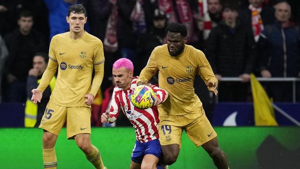 Barcelona's Franck Kessie, right, and Atletico Madrid's Antoine Griezmann challenge for the ball during the Spanish La Liga soccer match between Atletico Madrid and FC Barcelona at Civitas Metropolitano stadium in Madrid, Spain, Sunday, Jan. 8, 2023. (AP Photo/Manu Fernandez)