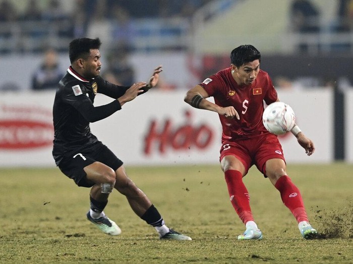 Vietnam's Doan Van Hau, right, battles for the ball against Indonesia's Saddle Ramdani during the ASEAN Football Federation (AFF) Mitsubishi Electric Cup 2022 semi-final match at My Dinh National Stadium in Hanoi, Vietnam, Monday, Jan. 9, 2023. (AP Photo/Nguyen Manh Quan)