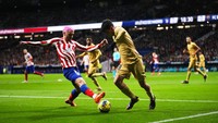 Antoine Griezmann dari Atletico Madrid (kiri) dan pemain Barcelona Pedri berebut bola selama pertandingan sepak bola La Liga Spanyol antara Atletico Madrid dan FC Barcelona di stadion Civitas Metropolitano di Madrid, Spanyol, Minggu(8/1/2023).  