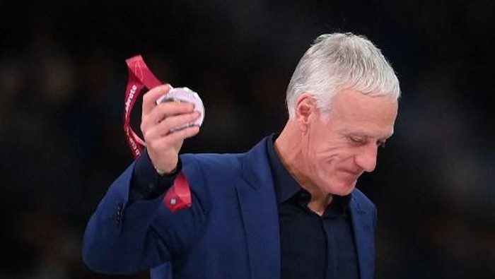 (FILES) In this file photo taken on December 18, 2022 Frances coach Didier Deschamps displays his silver medal during the Qatar 2022 World Cup trophy ceremony after losing the football final match between Argentina and France at Lusail Stadium in Lusail, north of Doha. - Didier Deschamps extends stay as France coach until 2026, he announced at the French Football Federations general assembly in Paris on January 7, 2023. (Photo by FRANCK FIFE / AFP)