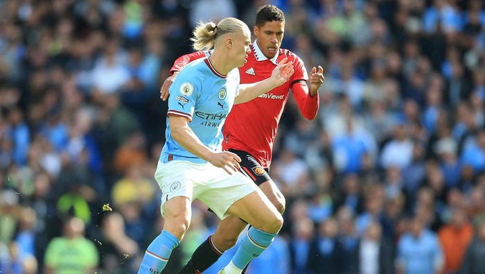 TOPSHOT - Manchester Citys Norwegian striker Erling Haaland (L) vies with Manchester Uniteds French defender Raphael Varane (R) during the English Premier League football match between Manchester City and Manchester United at the Etihad Stadium in Manchester, north west England, on October 2, 2022. - RESTRICTED TO EDITORIAL USE. No use with unauthorized audio, video, data, fixture lists, club/league logos or live services. Online in-match use limited to 120 images. An additional 40 images may be used in extra time. No video emulation. Social media in-match use limited to 120 images. An additional 40 images may be used in extra time. No use in betting publications, games or single club/league/player publications. (Photo by Lindsey Parnaby / AFP) / RESTRICTED TO EDITORIAL USE. No use with unauthorized audio, video, data, fixture lists, club/league logos or live services. Online in-match use limited to 120 images. An additional 40 images may be used in extra time. No video emulation. Social media in-match use limited to 120 images. An additional 40 images may be used in extra time. No use in betting publications, games or single club/league/player publications. / RESTRICTED TO EDITORIAL USE. No use with unauthorized audio, video, data, fixture lists, club/league logos or live services. Online in-match use limited to 120 images. An additional 40 images may be used in extra time. No video emulation. Social media in-match use limited to 120 images. An additional 40 images may be used in extra time. No use in betting publications, games or single club/league/player publications. (Photo by LINDSEY PARNABY/AFP via Getty Images)