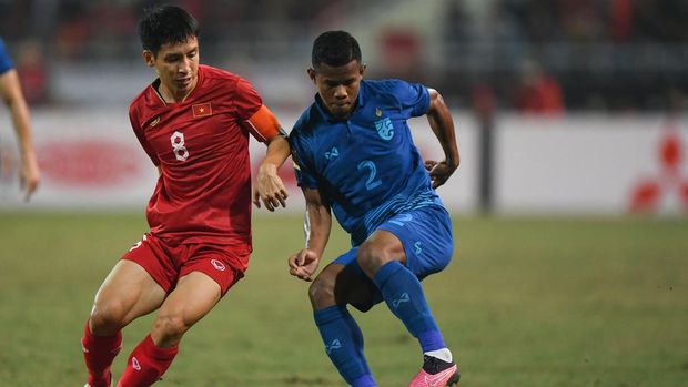 Vietnam's Do Hung Dung (L) fights for the ball with Thailand's Sasalak Haiprakhon during the first leg of the AFF Mitsubishi Electric Cup final football match between Vietnam and Thailand at My Dinh National Stadium in Hanoi on January 13, 2023. (Photo by Nhac NGUYEN / AFP)