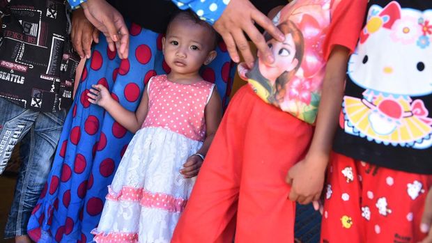 In this photograph taken on February 20, 2017, toddler Salsa Djafar stands with other children in her village in Gorontalo, in Indonesia's Gorontalo province, before taking part in a circumcision ceremony with her family. - Female circumcision -- also known as female genital mutilation or FGM -- has been practised for generations across Indonesia, which is the world's biggest Muslim-majority country, and is considered a rite of passage by many. (Photo by BAY ISMOYO / AFP) / TO GO WITH Indonesia-religion-rights-women,FEATURE by Olivia Rondonuwu