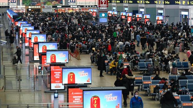 Passengers wait to check in at a railway station in Beijing on January 12, 2023, as the annual migration begins with people heading back to their hometowns for Lunar New Year celebrations. (Photo by WANG ZHAO / AFP)