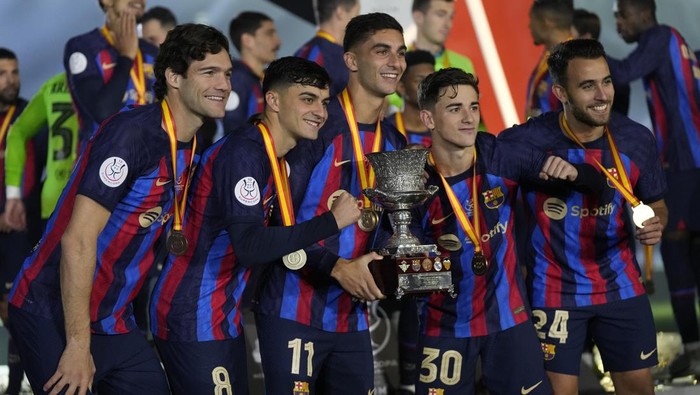 Barcelona players celebrate with a trophy after the won the final of the Spanish Super Cup between Barcelona and Real Madrid in Riyadh, Saudi Arabia, Sunday, Jan. 16, 2023. (AP Photo/Hussein Malla)