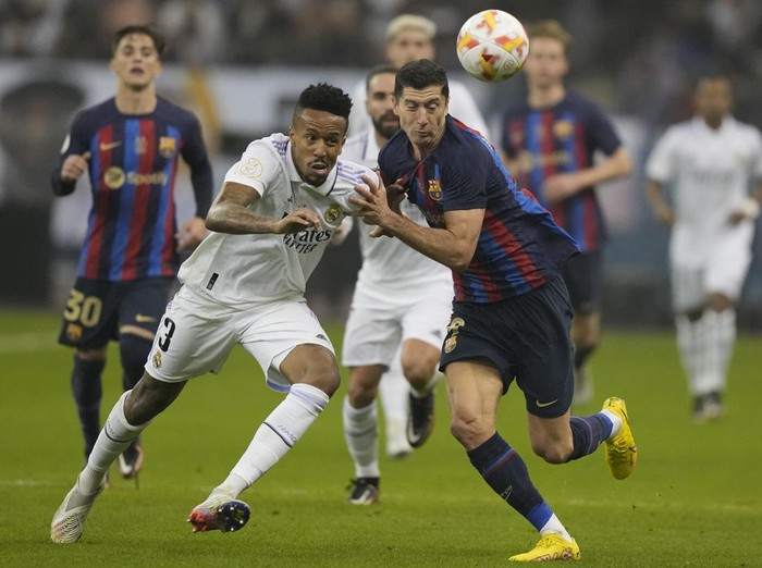 Real Madrids Eder Militao, left, and Barcelonas Robert Lewandowski fight for possession during the final of the Spanish Super Cup between Barcelona and Real Madrid in Riyadh, Saudi Arabia, Sunday, Jan. 16, 2023. (AP Photo/Hussein Malla)
