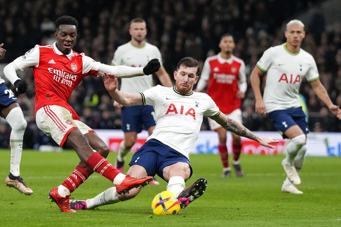 Tottenhams Pierre-Emile Hojbjerg, centre, challenges for the ball with Arsenals Eddie Nketiah during the English Premier League soccer match between Tottenham Hotspur and Arsenal at the Tottenham Hotspur Stadium in London, England, Sunday, Jan. 15, 2023. (AP Photo/Frank Augstein)