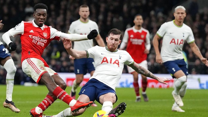 Tottenhams Pierre-Emile Hojbjerg, centre, challenges for the ball with Arsenals Eddie Nketiah during the English Premier League soccer match between Tottenham Hotspur and Arsenal at the Tottenham Hotspur Stadium in London, England, Sunday, Jan. 15, 2023. (AP Photo/Frank Augstein)