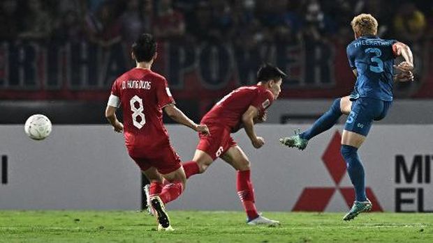 Thailand's Theerathon Bunmathan (L) shoots to score during the second leg of the AFF Cup final football match between Vietnam and Thailand at Thammasat Stadium in Bangkok on January 16, 2023. (Photo by Lillian SUWANRUMPHA / AFP)