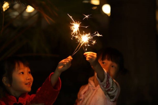 Menyalakan kembang api dan petasan untuk merayakan Imlek