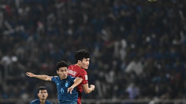 Vietnam's Nguyen Hoang Duc (R) and Thailand's Sarach Yooyen (2nd L) watch the ball during the second leg of the AFF Cup final football match between Vietnam and Thailand at Thammasat Stadium in Bangkok on January 16, 2023. (Photo by Lillian SUWANRUMPHA / AFP)