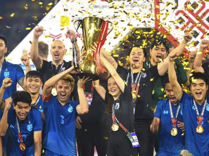 Thailand's Theerathon Bunmathan, left holding trophy, and team manager Nualphan Lamsam, right holding trophy, celebrate with the Thailand team after winning The ASEAN Football Federation (AFF) Cup final soccer match between Thailand and Vietnam at the Thammasat University stadium in Pathumthani province, Thailand, Monday, Jan. 16, 2023. (AP Photo/Kittinun Rodsupan)