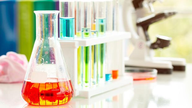 Close up Glassware with red liquid inside with test tubes and microscope in laboratory. Chemical pharmacy lab concept