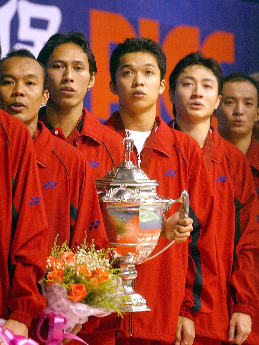 Indonesia's badminton team sing their country's national anthem as they hold on to the Thomas Cup after beating Malaysia in the Thomas Cup men's team badminton final in the southern Chinese city of Guangzhou 19 May 2002.  Indonesia beat Malaysia 3-2 to defend the title as the world best men's badminton team .                      AFP PHOTO/GOH Chai Hin (Photo by AFP)