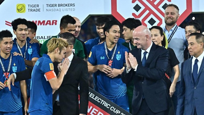 FIFA president Gianni Infantino (3rd R) applauds as Thailands Theerathon Bunmathan (3rd L) gestures in front of teammates celebrating winning the AFF Cup final football match against Vietnam at Thammasat Stadium in Bangkok on January 16, 2023. (Photo by Lillian SUWANRUMPHA / AFP)