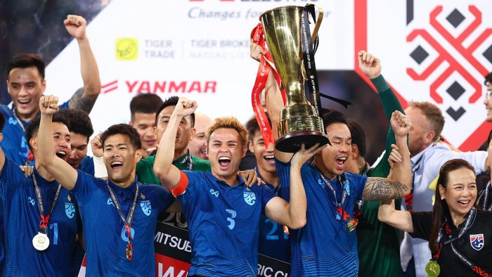 PATHUM THANI, THAILAND - JANUARY 16: Theerathon Bunmathan of Thailand (C) lift the AFF Mitsubishi Electric Cup trophy during the trophy presentation following the AFF Mitsubishi Electric Cup final second leg match between Thailand and Vietnam at Thammasat Stadium on January 16, 2023 in Pathum Thani, Thailand. (Photo by Pakawich Damrongkiattisak/Getty Images)