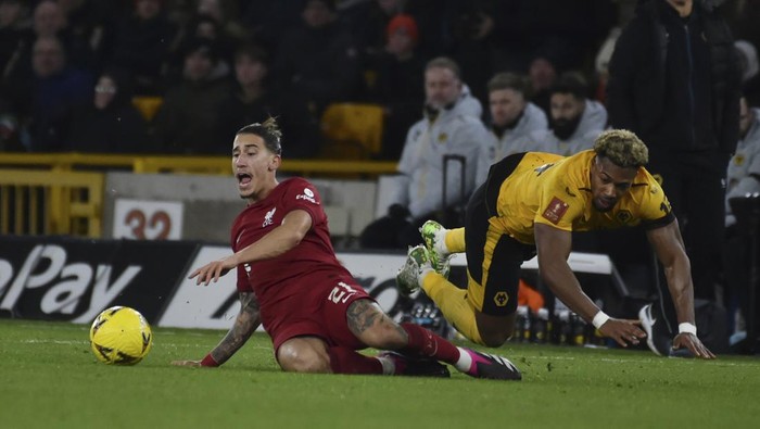 Wolverhampton Wanderers Adama Traore, right, and Liverpools Kostas Tsimikas challenge for the ball during the English FA Cup 3rd round replay soccer match between Wolverhampton Wanderers and Liverpool at Molineux stadium in Wolverhampton, England, Tuesday Jan. 17, 2023. (AP Photo/Rui Vieira)