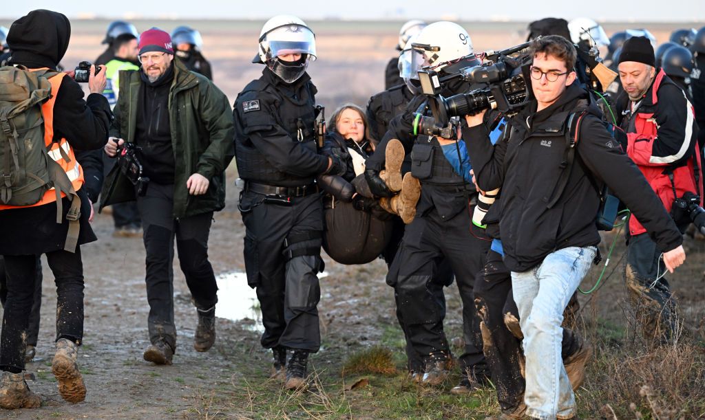 17 January 2023, North Rhine-Westphalia, Erkelenz: Police officers carry Swedish climate activist Greta Thunberg (M) out of a group of protesters and activists and away from the edge of the Garzweiler II opencast lignite mine. Activists and coal opponents continue their protests at several locations in North Rhine-Westphalia on Tuesday. Photo: Federico Gambarini/dpa (Photo by Federico Gambarini/picture alliance via Getty Images)