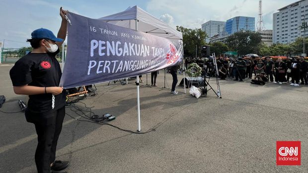 Spanduk berilustrasi muka Presiden Joko Widodo dengan hidung panjang seperti sosok Pinokio terbentang pada aksi 16 tahun Kamisan di sebrang Istana Negara Indonesia, Kamis (19/1).